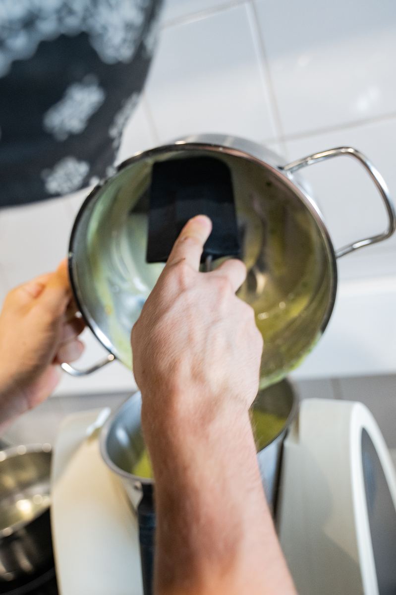 Molho a ser vertido de um tacho com uma espátula
