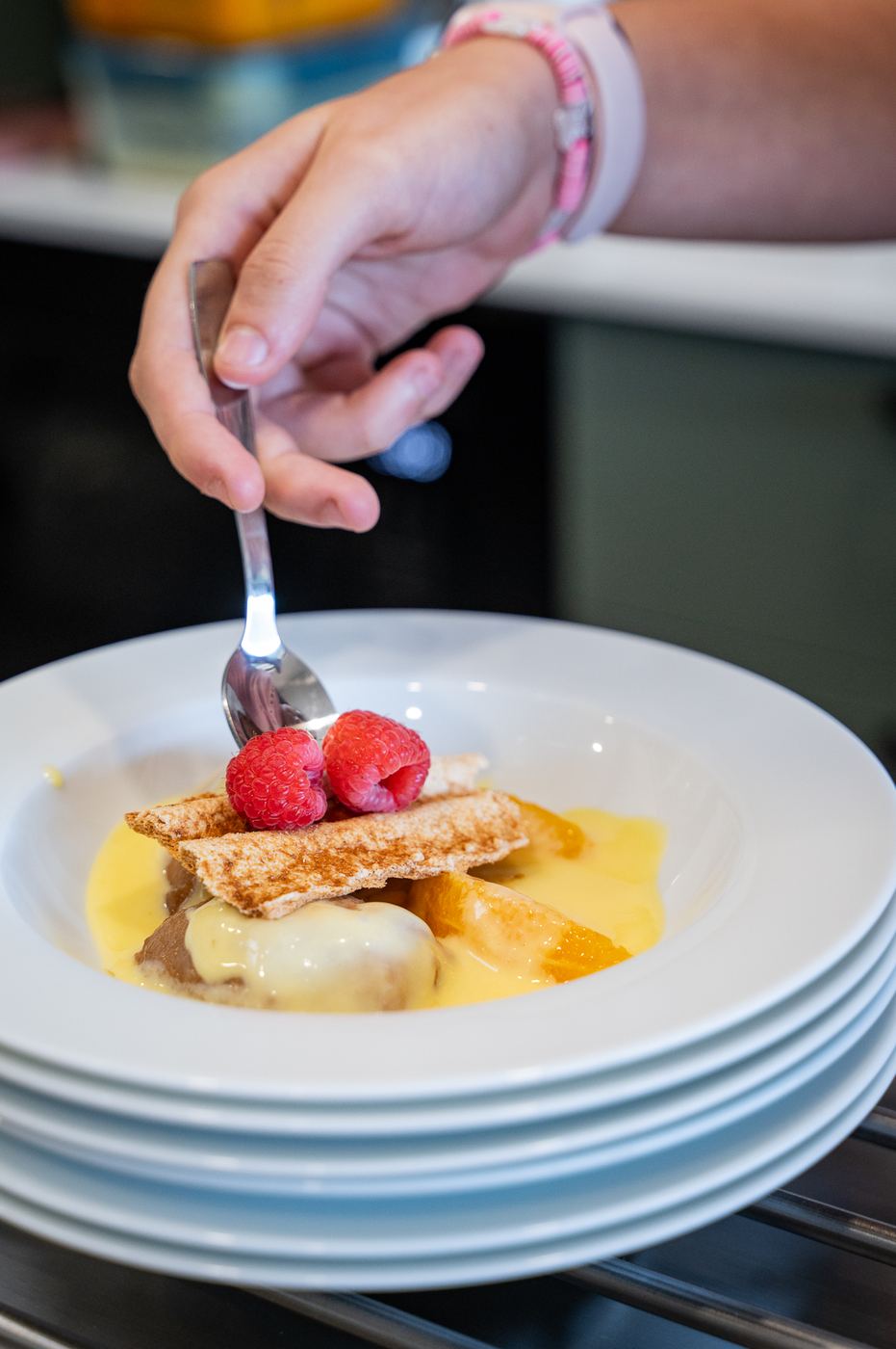 Empratamento de sobremesa com framboesas, laranja e creme
