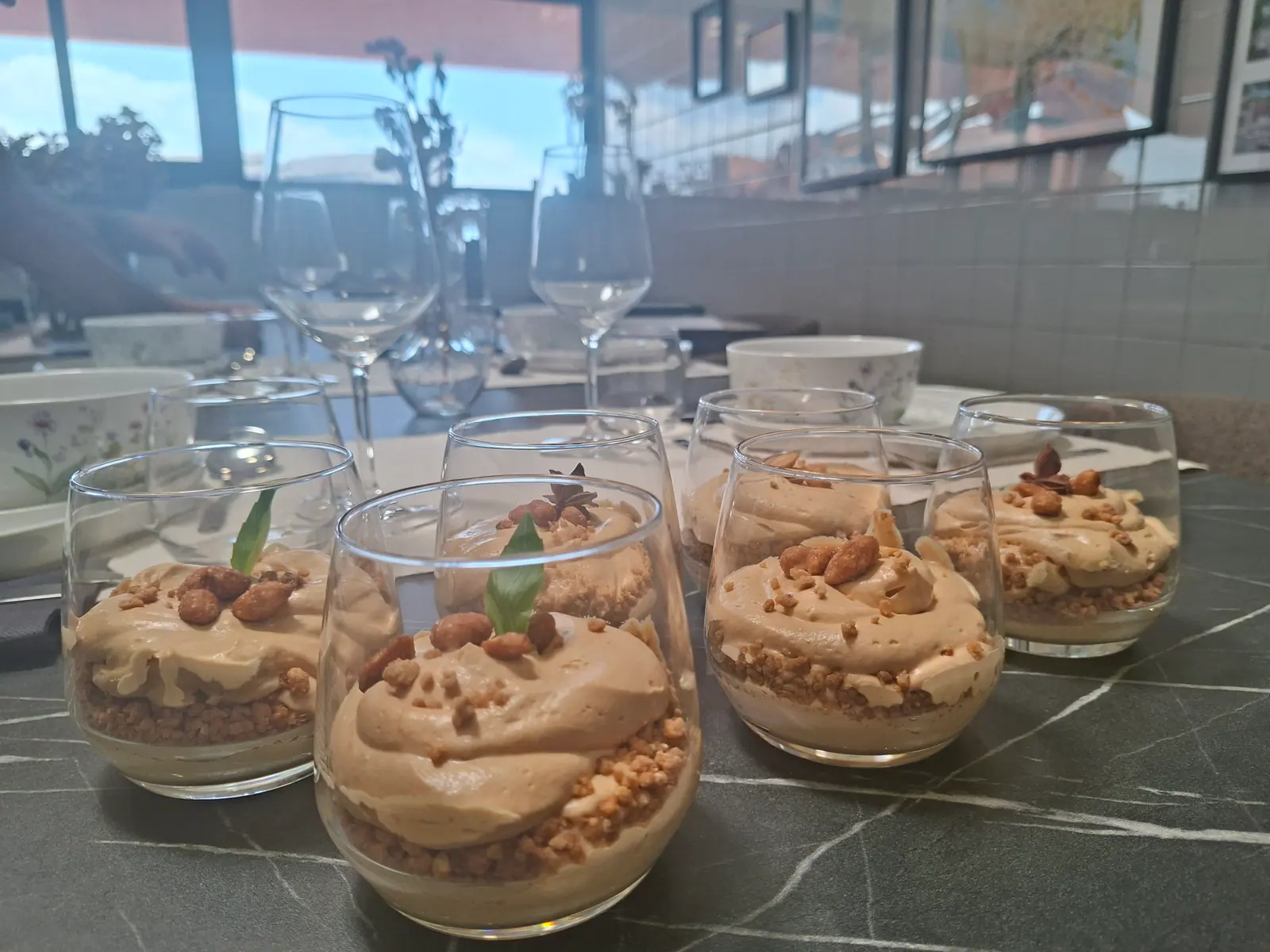 Caramel mousse desserts in glasses topped with candied peanuts