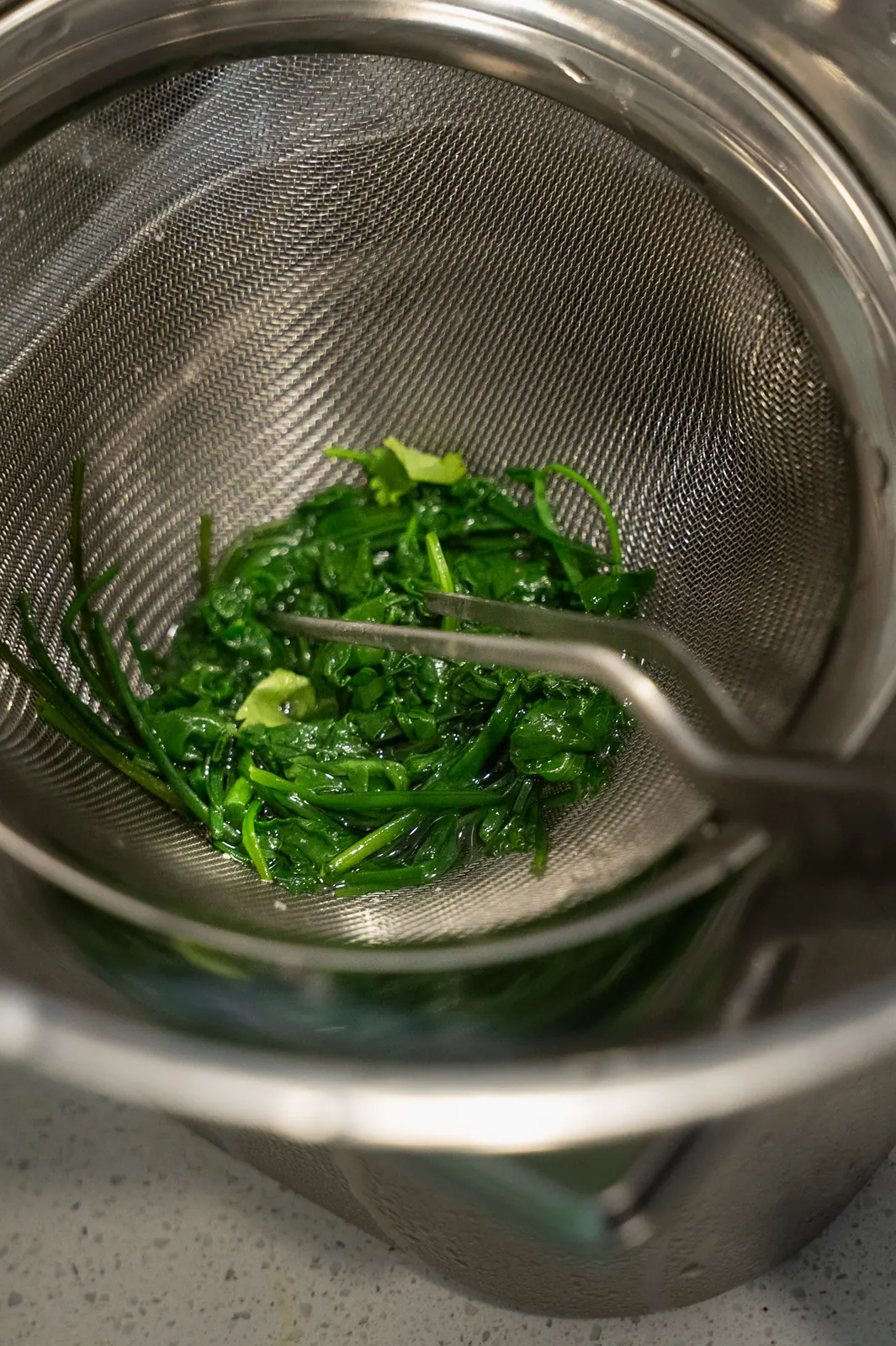 Blanched greens in a steel strainer